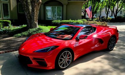 Red 2024 Chevrolet Corvette C8 parked in a residential driveway, showcasing mid-engine sports car design and exterior styling.