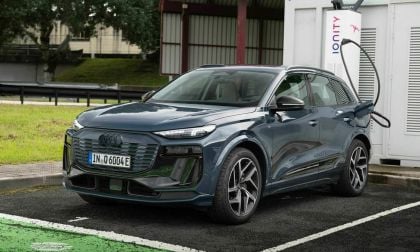 An Audi Q6 60E SUV parked at an electric charging station, plugged in and ready to charge.