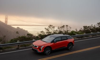 Red SUV driving on a road with the Golden Gate Bridge in the background.