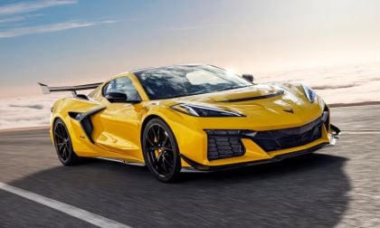Bright yellow 2025 Chevrolet Corvette Z06 driving on track with large rear wing, aerodynamic design and black wheels