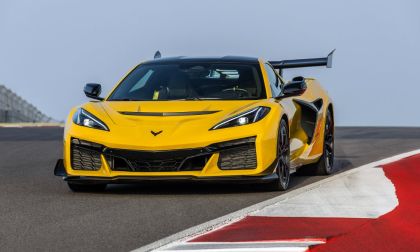 2025 Chevrolet Corvette Z06 in yellow driving aggressively on a race track, shown from a dynamic front angle with a large rear wing.