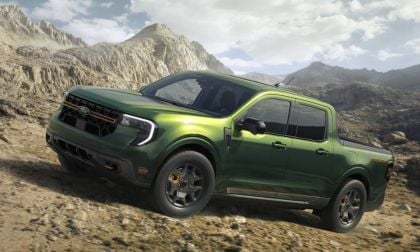 2024 Ford Maverick Tremor in metallic green, shown at three-quarter front angle climbing rocky mountain terrain, featuring off-road wheels and rugged styling.