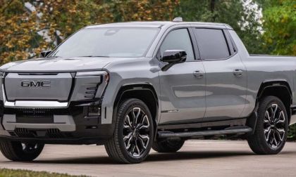 A silver 2025 GMC Sierra Denali pickup truck is shown featuring distinctive shaped LED lighting and black accents against a natural outdoor background.