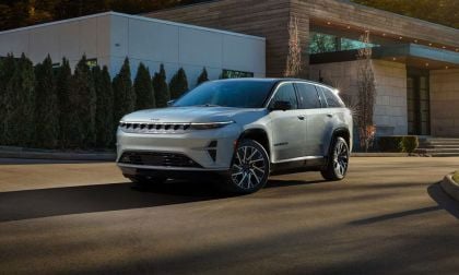 2025 Jeep Wagoneer S EV in pearl white, parked at modern architectural building with landscaped trees
