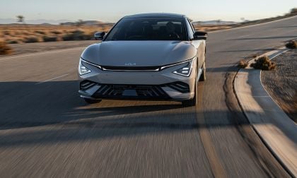 2025 Kia EV6 electric vehicle driving quickly along a desert road at sunset