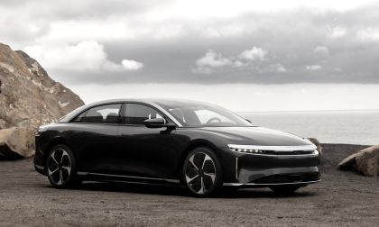 Photograph of a 2025 Lucid Air Touring electric vehicle in a two-tone color scheme, captured from a low angle that showcases the front three-quarter view of the car.