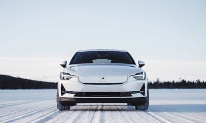 2025 Polestar 2, front view in snow, featuring a white exterior, distinctive headlights, and a minimalist grille.
