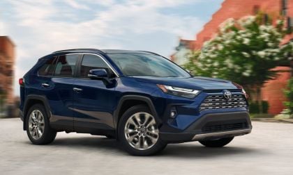A 2025 Toyota RAV4 in blue metallic paint photographed from the front three-quarter view, emphasizing its athletic stance and contemporary design.