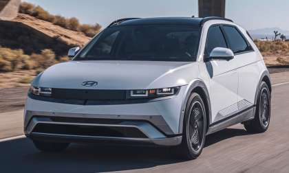 White 2025 Hyundai Ioniq 5 Limited driving on a desert highway in a front three-quarter action view.