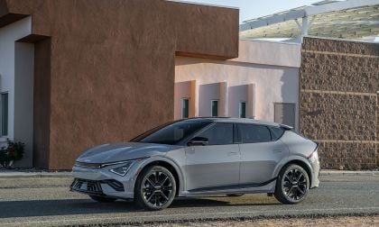 2025 Kia EV6 GT in silver parked in front of southwestern adobe building with solar canopy, front three-quarter view