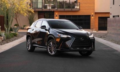 Black SUV parked in front of a modern house with desert landscaping.