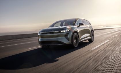 2026 Lucid Gravity electric SUV in gray, driving dynamically on highway at sunrise with sleek, aerodynamic profile