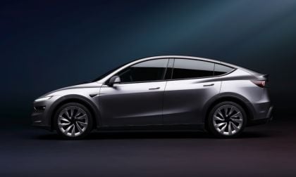Side profile of the 2026 Tesla Model Y Juniper in gray, highlighting its sleek coupe-SUV silhouette, redesigned headlights, and aerodynamic body lines.