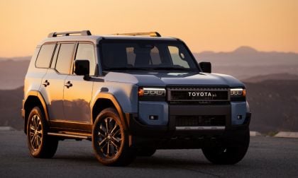 Blue Toyota SUV parked on a road at sunset, mountains visible in the background.