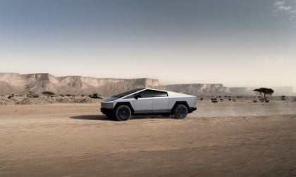 Tesla Cybertruck parked on rocky desert terrain under a clear sky