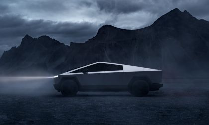 Side view of Tesla Cybertruck in a misty mountain setting, emphasizing angular stainless steel design and rugged styling.