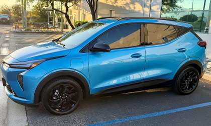 Blue 2027 Chevrolet Bolt RS shown from the passenger side in a parking lot.