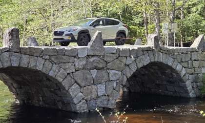 2026 Subaru Crosstrek Hybrid crosses a stone arch bridge in Central New Hampshire