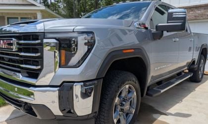 Cory's GMC Sierra Duramax.jpg: "Silver GMC Sierra HD pickup truck parked in suburban driveway, rugged chrome grille and bold wheel design prominent