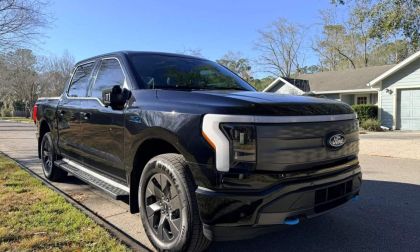 Ford F-150 Lightning electric pickup truck parked on a residential street, front three-quarter view
