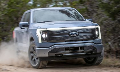 Ford F150 Lightning driving on dirt road kicking up dust