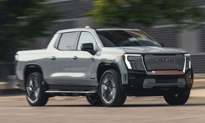 GMC Sierra EV electric pickup truck driving at speed with motion blur showing side profile