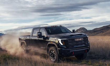 GMC Sierra HD AT4X heavy duty pickup truck driving off road kicking up dust