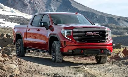 GMC Sierra 1500 driving off-road through a rugged desert landscape with hills and natural terrain