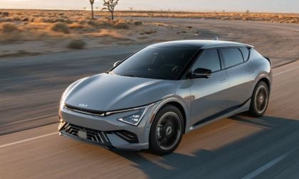 A gray 2025 Kia EV6 in a desert landscape, showcasing its aerodynamic design and advanced features on an open road.