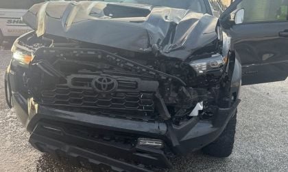 Jerry's Toyota Tacoma with severe front-end collision damage, showing a damaged grille, bumper, and hood from a front three-quarter view.