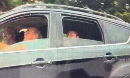 A family of three in a moving car viewed from the side. All appear to be laughing, most likely after telling Joseph what he claimed. The background shows blurred greenery.