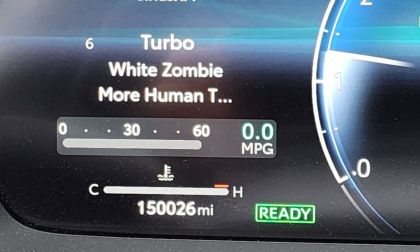 Digital instrument cluster display showing 150,026 miles with drive mode options visible, along with MPG and temperature gauges in a modern blue-lit interface.