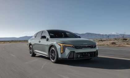 Kia K4 driving on highway with desert landscape in background