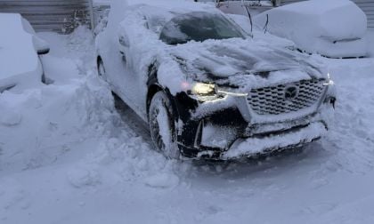Mazda CX-90 covered in snow after winter storm, demonstrating AWD capability in deep snow