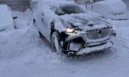 Mazda CX-90 covered in snow after winter storm, demonstrating AWD capability in deep snow