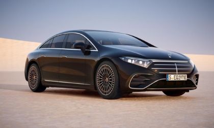 2025 Mercedes EQS Sedan in black, three-quarter view showing distinctive grille, LED headlights, and intricate alloy wheels.