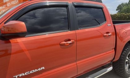 Orange color new Toyota Tacoma with tinted windows