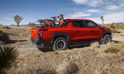 Red 2026 Chevy Silverado EV Trail Boss with motorcycles in bed