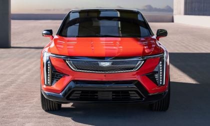 Front view of a sleek red Cadillac electric SUV showcasing modern design with sharp lines and distinctive LED headlights.