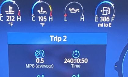 Ford F-150 dashboard display showing Trip 2 statistics including fuel economy of 0.5 MPG average and trip time of 240:10:50, with temperature and fuel level indicators visible at the top of the blue digital interface.