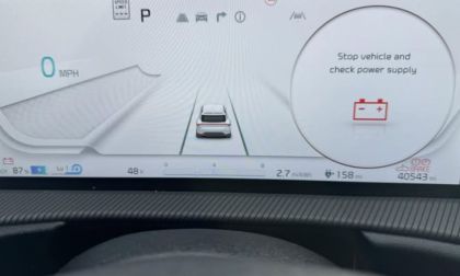 Vehicle dashboard display showing "Stop vehicle and check power supply" warning message with 0 MPH speed reading and battery icon, indicating electrical system issue.