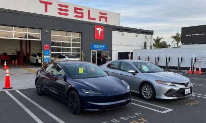 Tesla Model Y and a Toyota Camry in front of a Tesla Service Center