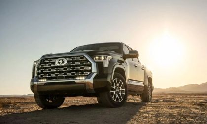 A black 2022 Toyota Tundra is on a desert terrain with a striking grille is showcased against a bright sunset, evoking a rugged and adventurous tone.