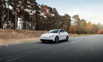 White Tesla Model Y driving in a rural area