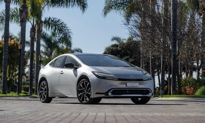 Toyota Prius Prime parked on street with palm trees and sunny background