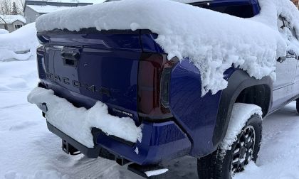 Toyota Tacoma pickup truck with tailgate frozen shut and covered in snow during winter