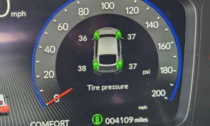 An in-dash vehicle tire pressure display shows that tires are overinflated.