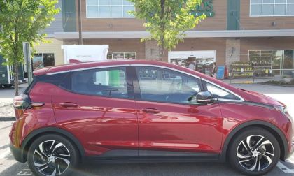 A Chevrolet Bolt in a briloiant red color is charging on a DC electric vehicle charger