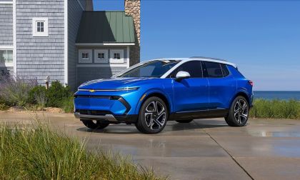Blue Chevrolet Equinox EV parked near coastal home with ocean view