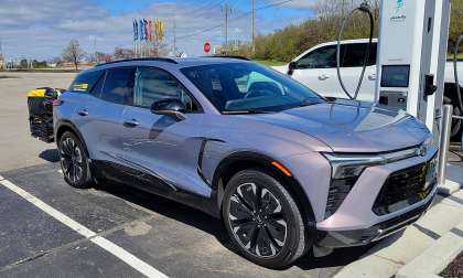 Front three-quarter view of Christopher’s Chevy Blazer EV connected to a fast charger during a road trip stop.